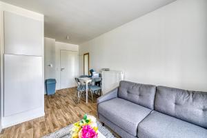 ein Wohnzimmer mit Sofa und Tisch in der Unterkunft Moulin à Vent A14 - Appt pour 4 avec balcon in Bondy + 3 Fotos