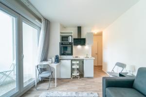 une cuisine et un salon avec un canapé et une table dans l'établissement Moulin à Vent A03 - Studio avec terrasse, à Bondy