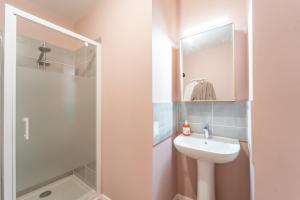 une salle de bains avec un lavabo blanc et une douche dans l'établissement Moulin à Vent A03 - Studio avec terrasse, à Bondy