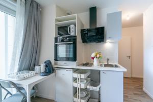 une cuisine avec un comptoir blanc et un évier dans l'établissement Moulin à Vent A03 - Studio avec terrasse, à Bondy 4 autres photos