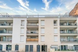 une vue extérieure d'un bâtiment blanc avec des balcons dans l'établissement Moulin à Vent A03 - Studio avec terrasse, à Bondy