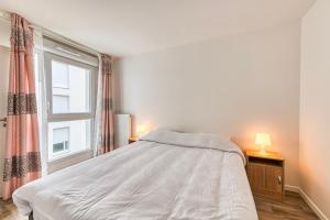 ein Schlafzimmer mit einem Bett und einem Fenster in der Unterkunft Moulin à Vent A21 - Appt pour 4 in Bondy