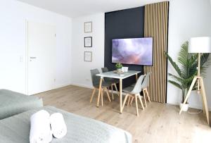 ヴォルフスブルクにあるGRAzzOO 3 getrennte Zimmer 3x Smart TVのベッドルーム(テーブル付)、ダイニングルーム