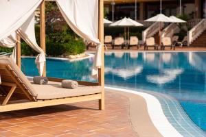 a lounge chair next to a swimming pool at Valentin Son Bou in Son Bou +87 photos