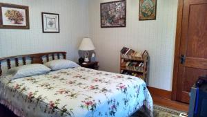 a bedroom with a bed with a floral bedspread at Fish & Loaves Bed and Breakfast in Numidia