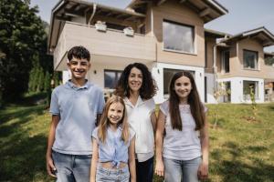 a family standing in front of a house at Gutzeit-Appartements mit privater Infrarotkabine in Bad Hindelang +35 photos