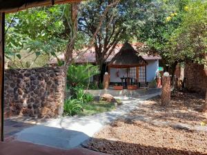 a small house with a stone wall at Maroela Gardens Guesthouse in Thabazimbi