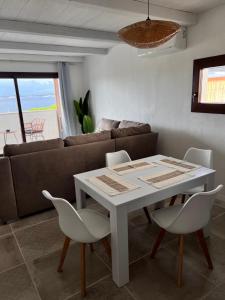 un soggiorno con un tavolo e un divano di Corallo by Residence Rena Bianca a Baja Sardinia