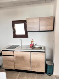 una piccola cucina con un lavandino e una finestra di Corallo by Residence Rena Bianca a Baja Sardinia Altre 11 foto