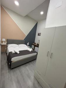 une chambre avec un grand lit avec des draps blancs dans l'établissement Garibaldi guest house, à Naples