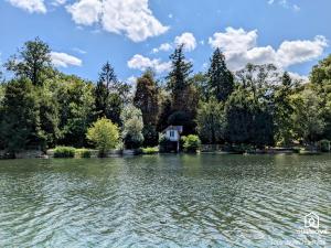 a house in the middle of a lake at Ô fil de l'eau - Jardin, Cabanon d'Antan, Parking in Olivet