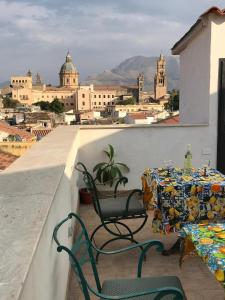 a table and chairs on a balcony with a view of a city at Casa Rosa in Palermo