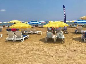 a group of chairs and umbrellas on a beach at Göksel Apart in Mersin