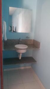 een badkamer met een witte wastafel en een spiegel bij Pousada Maré in Ponta do Mel +64 foto's