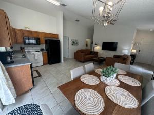 a kitchen and a living room with a table and chairs at A Hidden Gem Southern Dunes Villa Golf Views in Haines City
