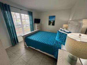 a bedroom with a blue bed and a window at A Hidden Gem Southern Dunes Villa Golf Views in Haines City