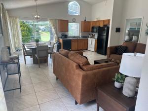 a living room and kitchen with a couch and a table at A Hidden Gem Southern Dunes Villa Golf Views in Haines City +13 photos