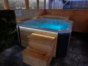a hot tub with blue water in a building at Domki Złote Piaski Kryty Basen Sauna Jacuzzi in Jastrzębia Góra