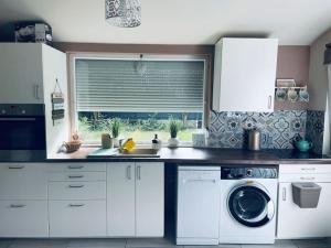 a kitchen with a washing machine and a window at BB-LAK víkend in Szigetmonostor