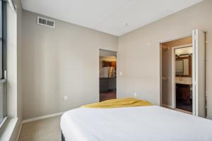 een slaapkamer met witte muren en een wit bed bij Two CozySuites Mill District #04 & 01 in Minneapolis