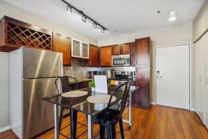 een keuken met een tafel en een roestvrijstalen koelkast bij Two CozySuites Mill District #04 & 01 in Minneapolis +42 foto's