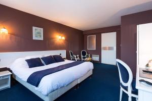 a hotel room with a bed and a desk and chairs at Hotel De Clisson Saint Brieuc in Saint-Brieuc