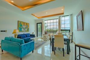 a living room with a blue couch and a table at Villa Viola 7 Bedroom, Fully Staffed, on the Golf Course in Laguna Phuket