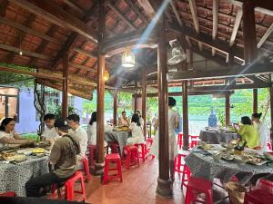 a group of people sitting at tables in a restaurant at Son River House in Phong Nha