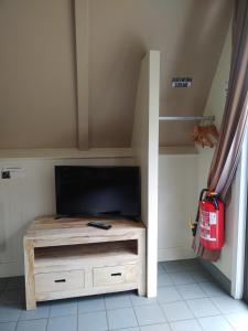 a room with a tv and a fire hydrant in a room at Gezellig vakantiehuis in Mol
