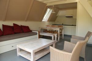 a living room with a couch and a table and chairs at Gezellig vakantiehuis in Mol