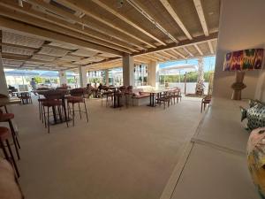 un comedor con mesas y sillas y una habitación grande en Punta Candor Suites, en Rota