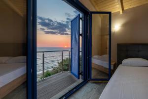 a bedroom with a balcony with a view of the ocean at Casa Azzura in Mytikas