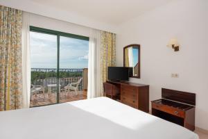 a bedroom with a bed and a large window at Valentin Son Bou in Son Bou