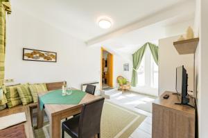 a living room with a table and a couch at Weingut Apartment Hildegard Gangl in Illmitz