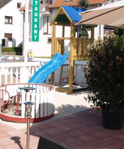 a playground with a blue slide and a play structure at Hotel zum Ochsen in Bietigheim