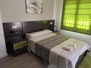 a bedroom with a bed and a table with two towels at LA GARRUCHa in Argamasilla de Alba