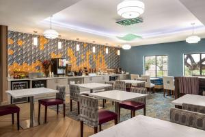 a restaurant with tables and chairs and a kitchen at La Quinta by Wyndham San Antonio North Stone Oak in San Antonio