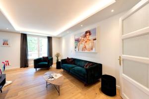 a living room with a green couch and a table at LE MIRAGE Luxury T4 avec garage in Annecy