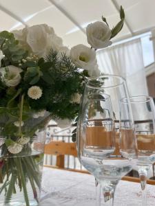 deux verres à vin et un vase avec des fleurs sur une table dans l'établissement beb Dragonara apartment 2, à Torre Maggiore