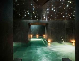 a swimming pool with lights in a dark room at Hyatt Centric Milan Centrale in Milan
