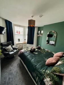 a bedroom with a bed and a chair and a mirror at Stylish and Chic Seaside Apartment in Southend-on-Sea +5 photos