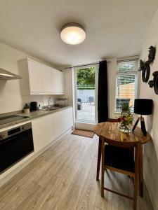 a kitchen with a wooden table and a dining room at Stylish and Chic Seaside Apartment in Southend-on-Sea