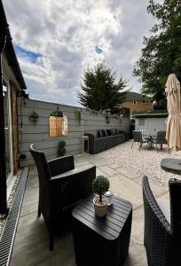 a patio with chairs and a table and a umbrella at Stylish and Chic Seaside Apartment in Southend-on-Sea