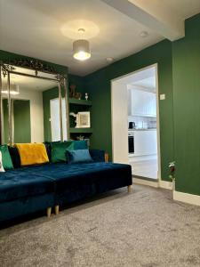 a living room with a blue couch and a mirror at Stylish and Chic Seaside Apartment in Southend-on-Sea