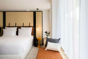 a bedroom with a white bed and a large window at FirstName Bordeaux, Part of JdV by Hyatt in Bordeaux