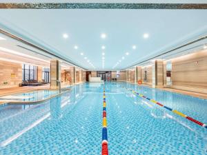 een groot zwembad in een gebouw bij Swissotel Xi' an Xinxing Hot Spring in Xi'an
