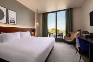 a hotel room with a bed and a desk and a window at Dolce by Wyndham Barcelona Resort in Sant Esteve Sesrovires
