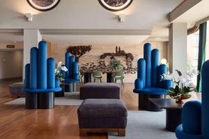 een lobby met blauwe stoelen en een tafel bij Dolce by Wyndham Barcelona Resort in Sant Esteve Sesrovires