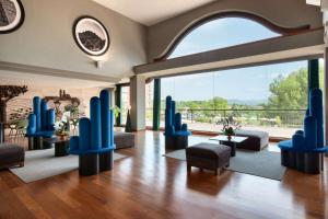 een lobby met blauwe stoelen en een groot raam bij Dolce by Wyndham Barcelona Resort in Sant Esteve Sesrovires