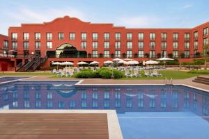 een hotel met een zwembad voor een gebouw bij Dolce by Wyndham Barcelona Resort in Sant Esteve Sesrovires +88 foto's